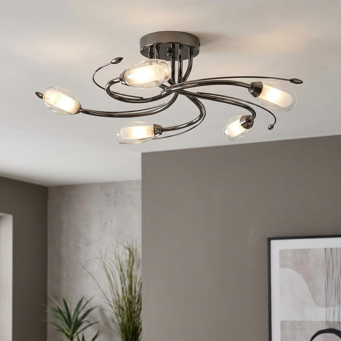 Pandora 5-light mirror black ceiling fixture with elegant curved arms and glowing glass shades in a modern room.