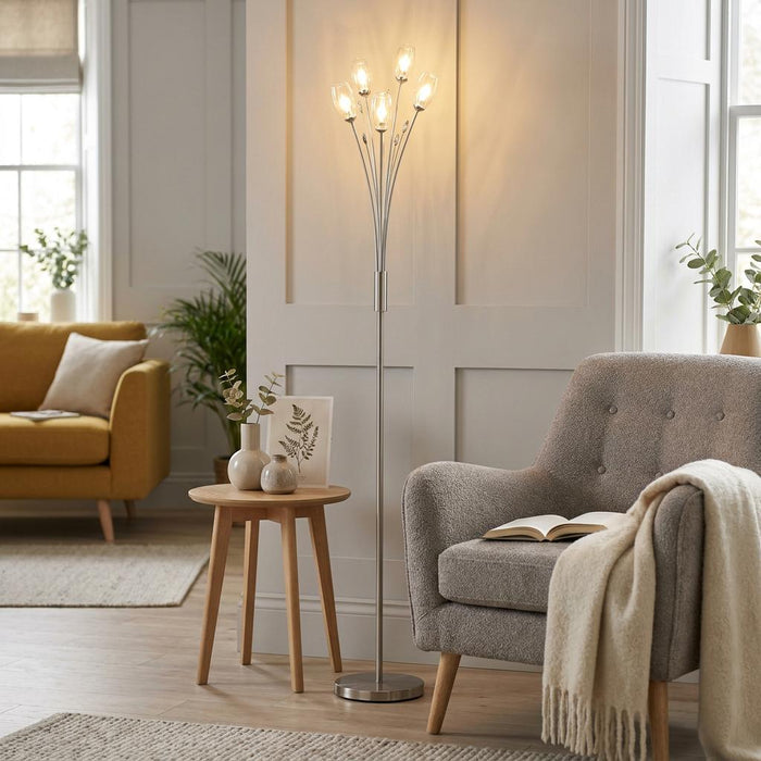 Pandora antique chrome floor lamp with five tulip-shaped glass shades illuminating a cozy living room nook.