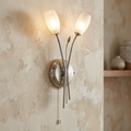 Pandora antique chrome two-light wall sconce with frosted tulip glass shades on a textured beige wall.