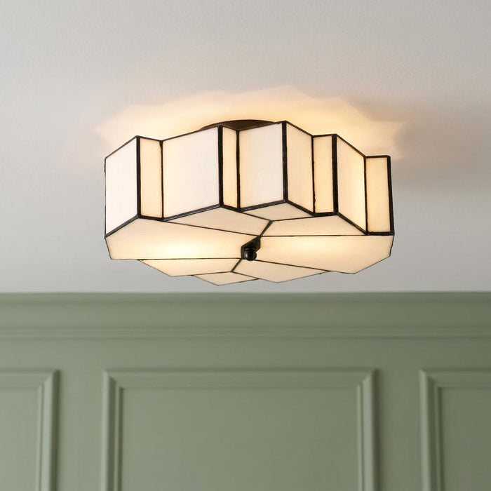 Geometric white Tiffany flush mount ceiling light with dark lead lines, illuminated against a white ceiling.