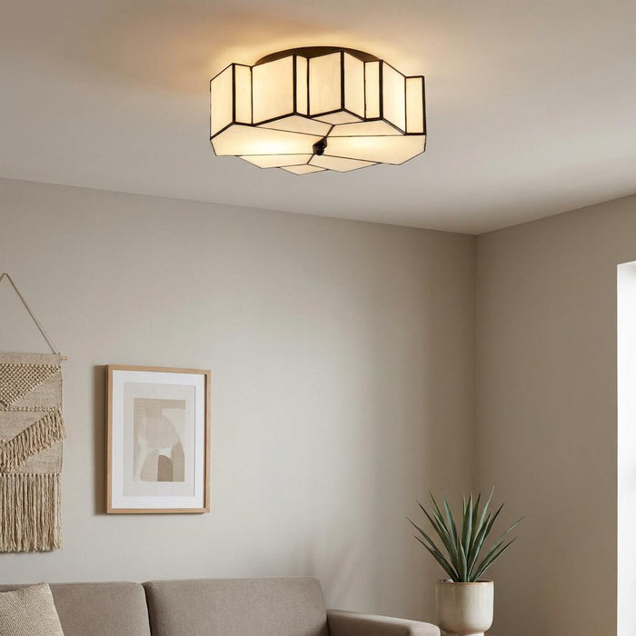 Geometric Tiffany-style flush ceiling light with white glass and black metal trim in a modern living room.