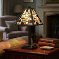 Phoenix Tiffany Table Lamp with an amber mosaic shade on a wooden side table in a cozy living room.