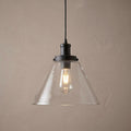 Black ceiling pendant light with a clear pyramid glass shade and an illuminated vintage bulb.