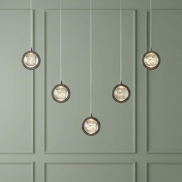 Quartz 5-light pendant with chrome-framed bubble glass shades staggered against a sage green paneled wall.