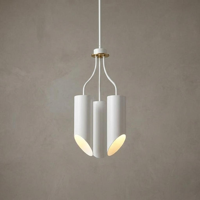 Modern three-light chandelier with white cylindrical shades and aged brass accents against a grey wall.