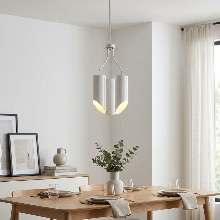 Modern white and brass three-light chandelier with cylindrical shades hanging over a contemporary wooden dining table.