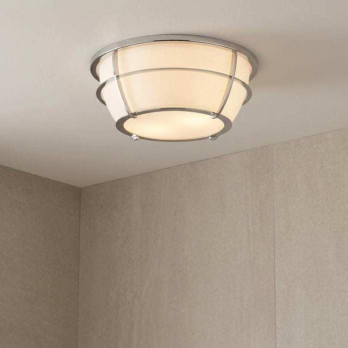 Quoizel Chance chrome bathroom ceiling light with a white glass shade and metal cage design on a beige ceiling.