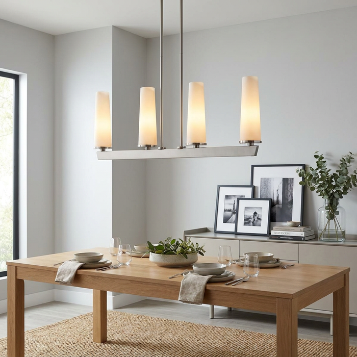 A 4-light linear pendant with brushed nickel finish and opal glass shades hangs over a modern dining table.