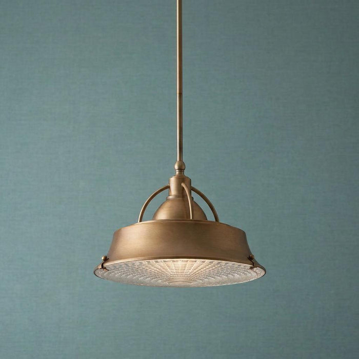 A copper pendant light with a textured glass diffuser hangs against a blue-green textured wall.