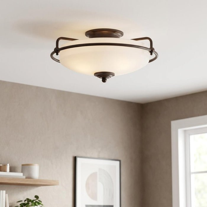 A flush mount ceiling light with a frosted glass dome and dark bronze metal frame in a modern room.
