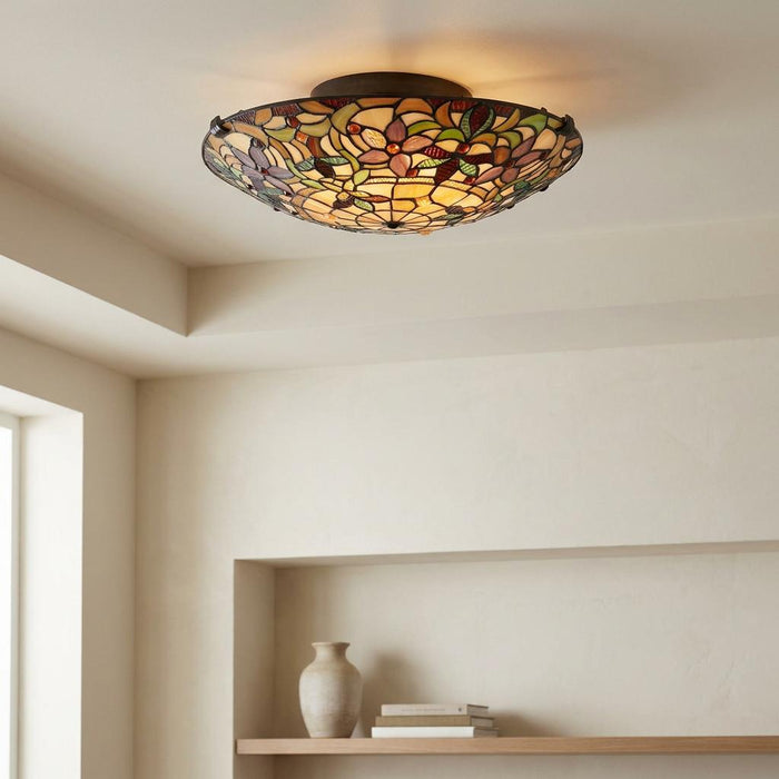 Floral Tiffany-style stained glass flush mount ceiling light glowing against a white ceiling.