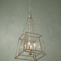 Quoizel Lakeside 4 light gold pendant ceiling light with a square cage and rippled glass against a green wall.
