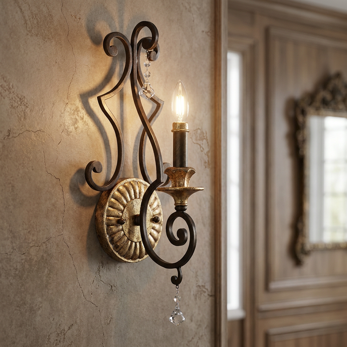 Ornate Quoizel Marquette wall light with bronze scrollwork and crystal accents mounted on a textured stone wall.