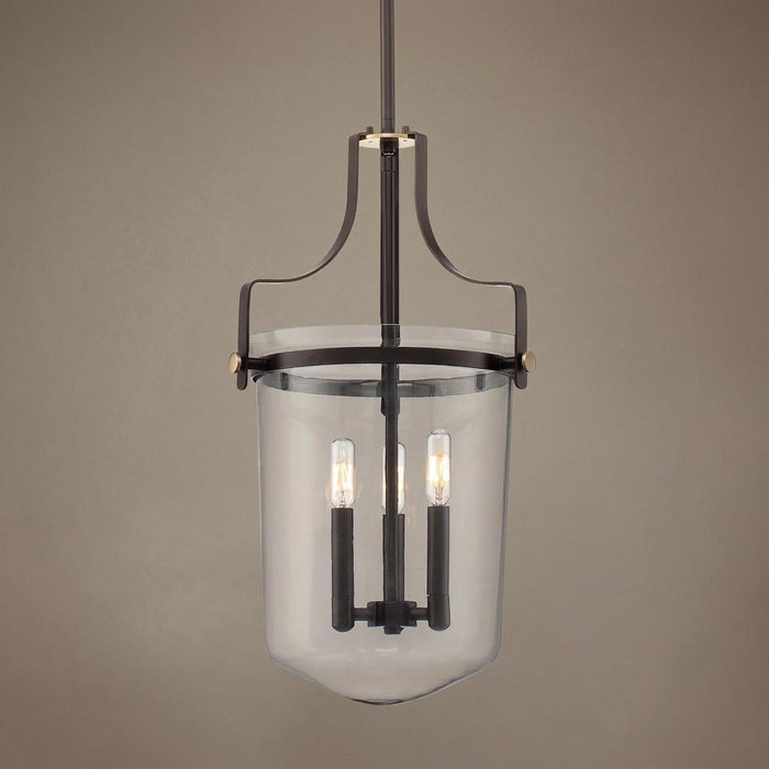 Bronze pendant light with curved metal frame, clear glass jar shade, and three lit vintage bulbs.