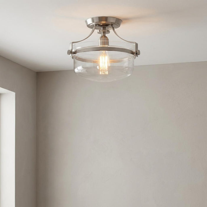Quoizel Penn Station brushed nickel semi-flush light with a clear glass shade on a white ceiling.