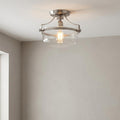 Quoizel Penn Station brushed nickel semi-flush light with a clear glass shade on a white ceiling.