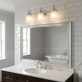 Quoizel Swell 3-light chrome wall light with frosted glass shades over a mirror in a white-tiled bathroom.