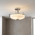 Quoizel Taylor 3-light semi-flush bathroom fixture with a chrome frame and white opal glass shade against a grey wall.