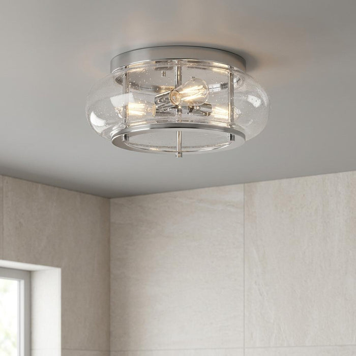 Chrome flush mount ceiling light with three lit Edison bulbs and clear seeded glass in a tiled bathroom.