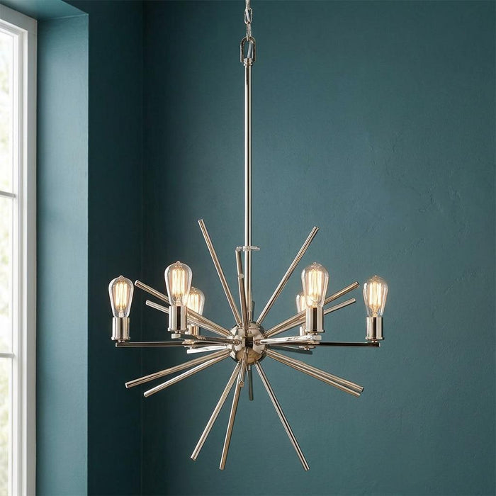 Silver six-light starburst chandelier with vintage bulbs hanging against a dark teal wall.