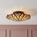 Circular Tiffany semi-flush ceiling light with geometric stained glass floral pattern.