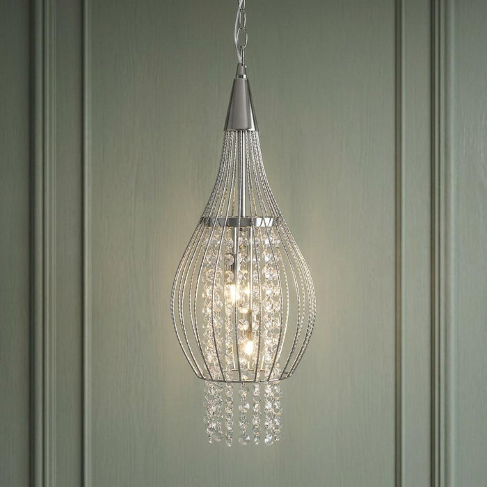 Chrome teardrop cage pendant light with interior hanging crystals against a green paneled wall.