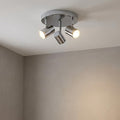 Rollo 3-light chrome flush ceiling spotlight with adjustable cylindrical heads glowing in a neutral room.