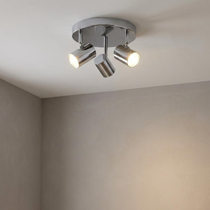 Rollo 3-light chrome flush ceiling spotlight with adjustable cylindrical heads glowing in a neutral room.