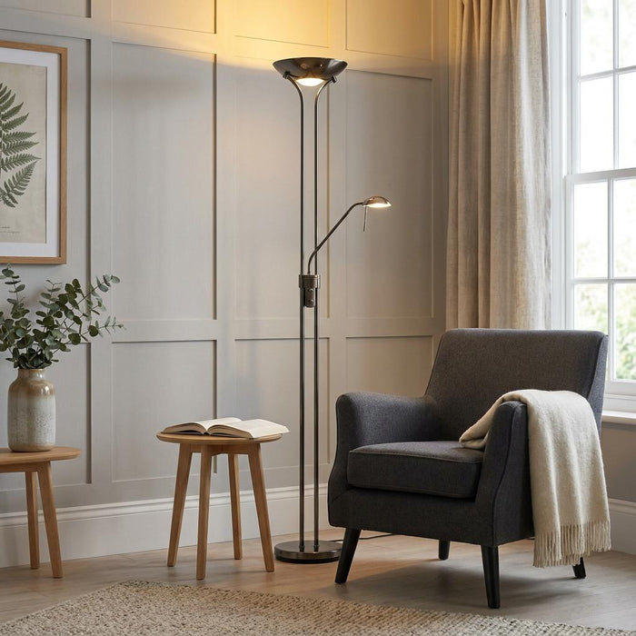 Rome black chrome mother and child floor lamp illuminating a cozy living room reading nook with a grey armchair.