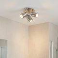 Samson silver three-light flush bathroom ceiling spotlight with three lit adjustable heads.