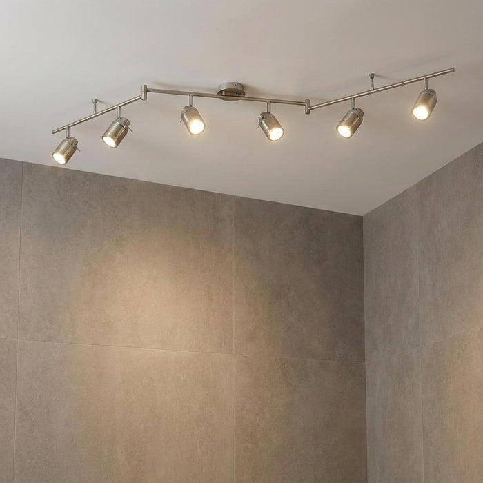Samson 6-light silver bathroom adjustable split-bar spotlight with lit bulbs on a white ceiling.