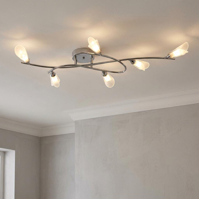 Six-light chrome flush ceiling light with frosted leaf shades on curved arms in a modern room.