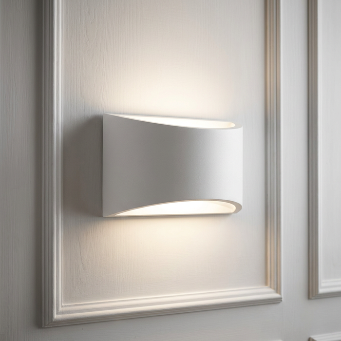 Curved white plaster wall light emitting upward and downward light on a classic white paneled wall.