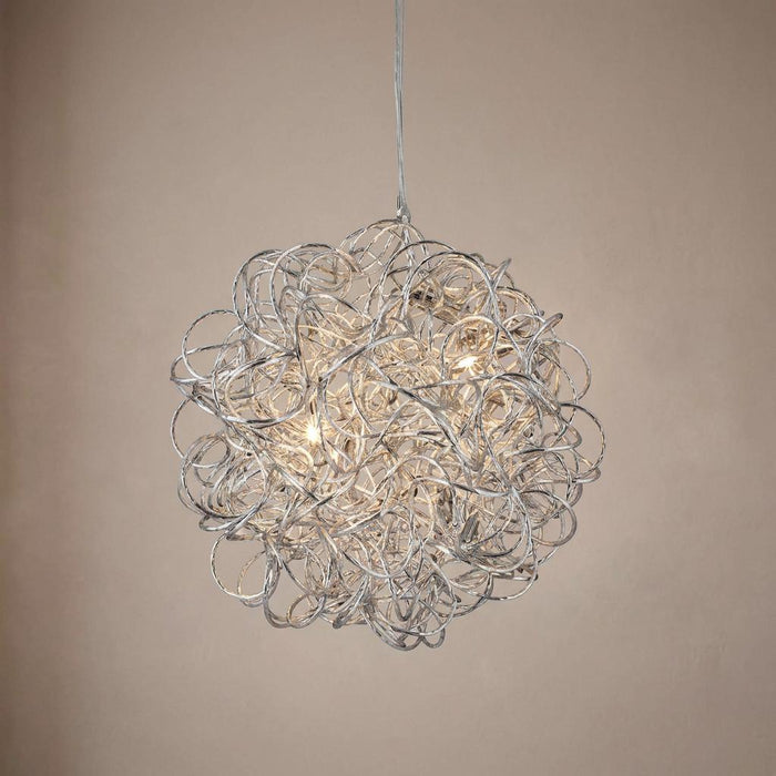 Spherical ceiling pendant light made of tangled silver wire loops with warm glowing bulbs against a beige wall.