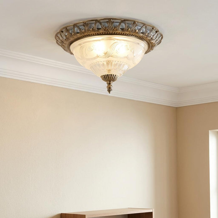 Antique brass ceiling flush light with an etched frosted glass bowl, mounted on a white ceiling.