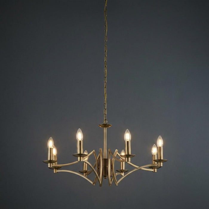 Eight-light antique brass chandelier with candle-style bulbs and elegant curved arms against a dark background.