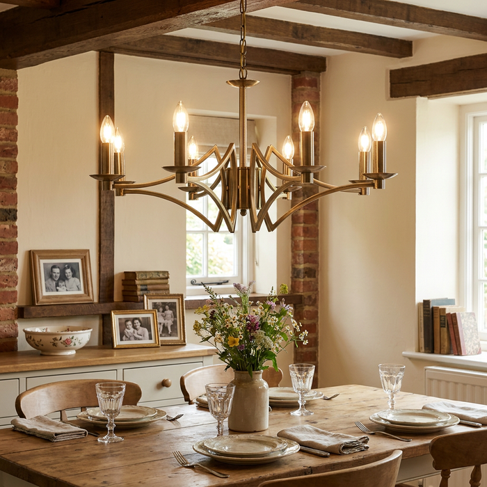 Searchlight Ascot 8 light antique brass chandelier hanging in a rustic dining room with wooden beams.