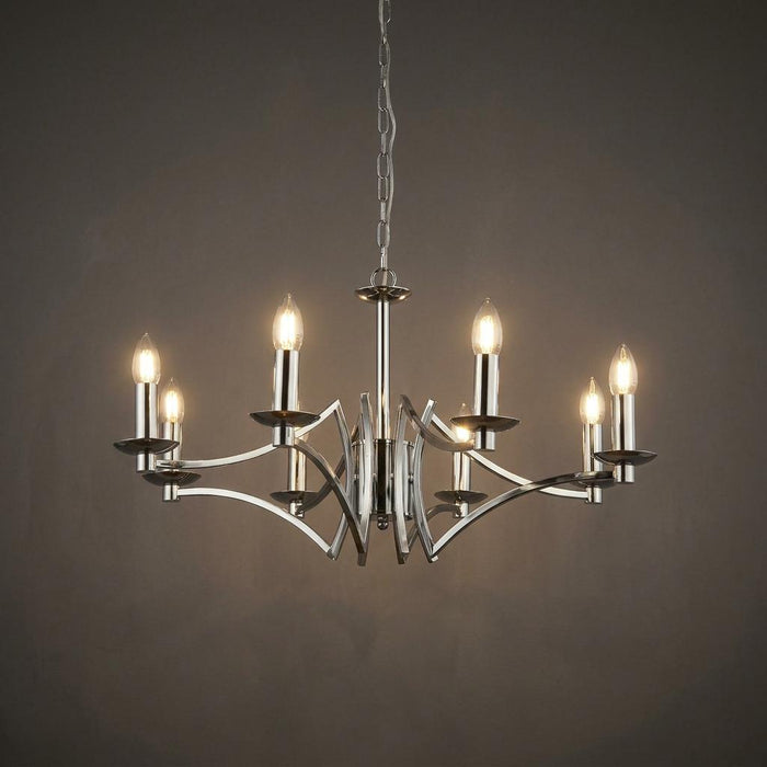 Polished chrome 8-light chandelier with curved arms and lit candle bulbs against a dark grey background.