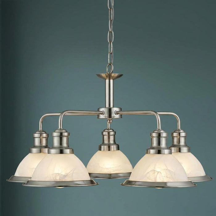 Five-light satin silver ceiling pendant with frosted marble-effect glass shades against a teal background.