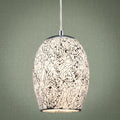 White mosaic glass pendant light with a crackle pattern, hanging against a green textured wall.
