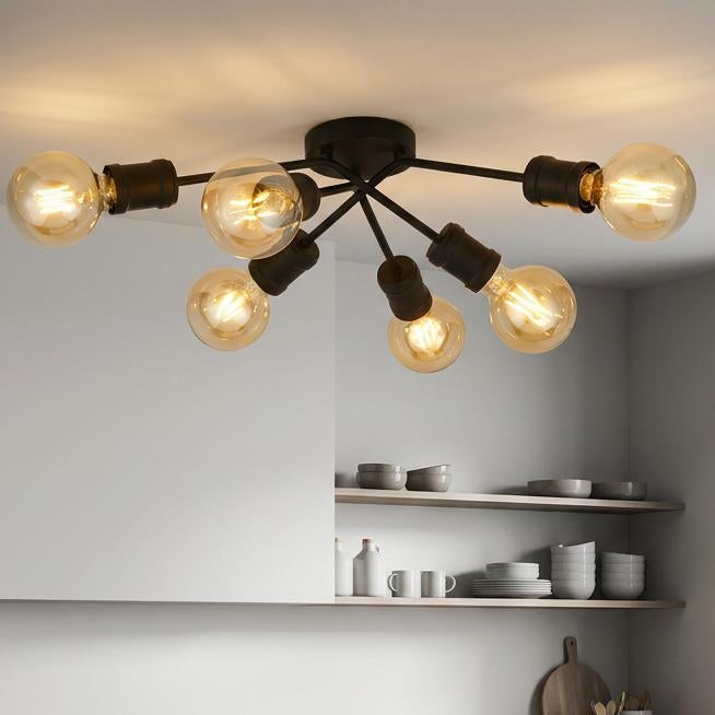 Modern black 6-light flush ceiling fixture with amber bulbs illuminating a minimalist grey kitchen.