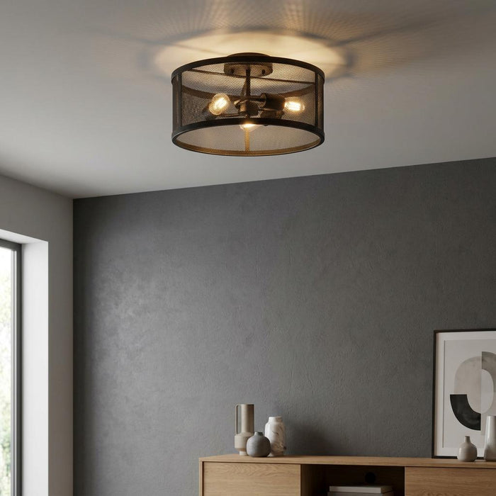 Searchlight Fishnet 3-light black mesh drum flush ceiling light illuminated in a modern room with a grey wall.
