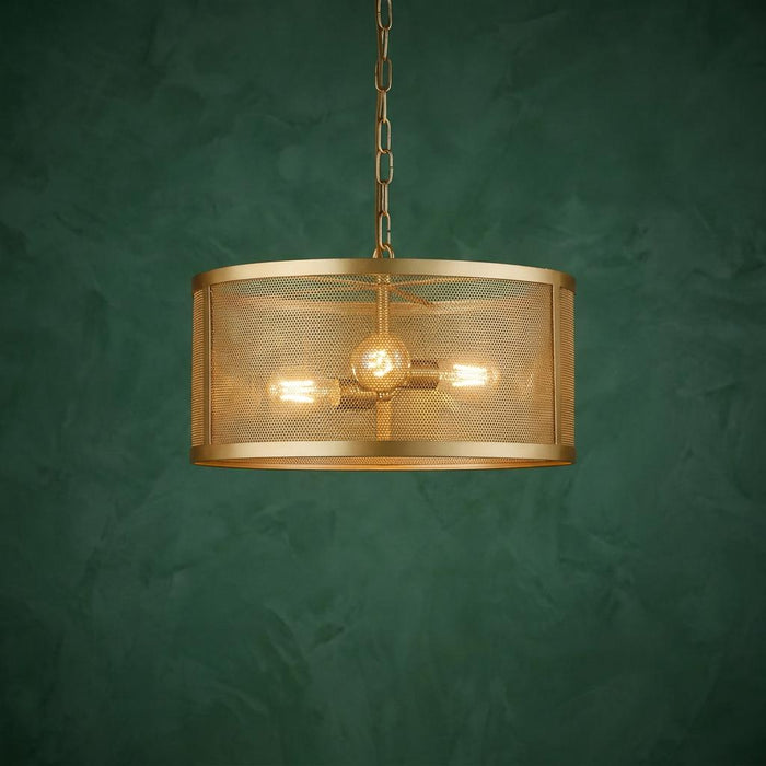 A three-light gold drum pendant with a fishnet mesh shade hangs against a dark green textured wall.