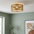 Modern gold fishnet drum ceiling light fixture on a white ceiling in a room with light green walls.