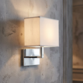 Modern chrome wall light with a rectangular white fabric shade mounted on a textured gray wall.