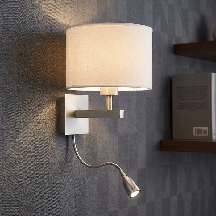 Silver dual-arm wall light with a white fabric shade and flexible LED reading arm on a textured grey wall.