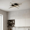 Modern black LED ceiling light with four intersecting bars illuminated in a contemporary kitchen.