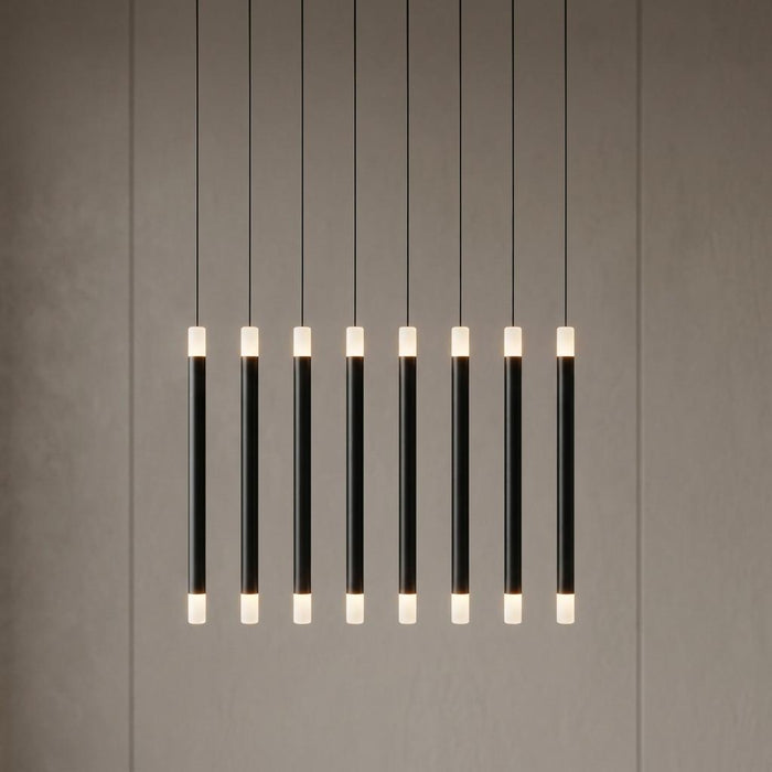 Linear pendant with eight black wands and glowing frosted tips, suspended against a neutral wall.