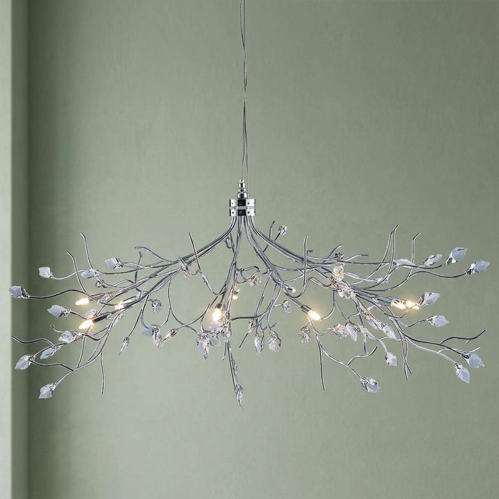 Silver branch-style 8-light ceiling pendant with crystal leaves against a light green wall.