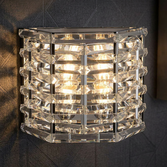 Shoal 2-light polished nickel wall light with crystal glass bars glowing on a dark patterned wall.